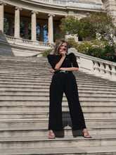 A woman wears black high-waisted pants